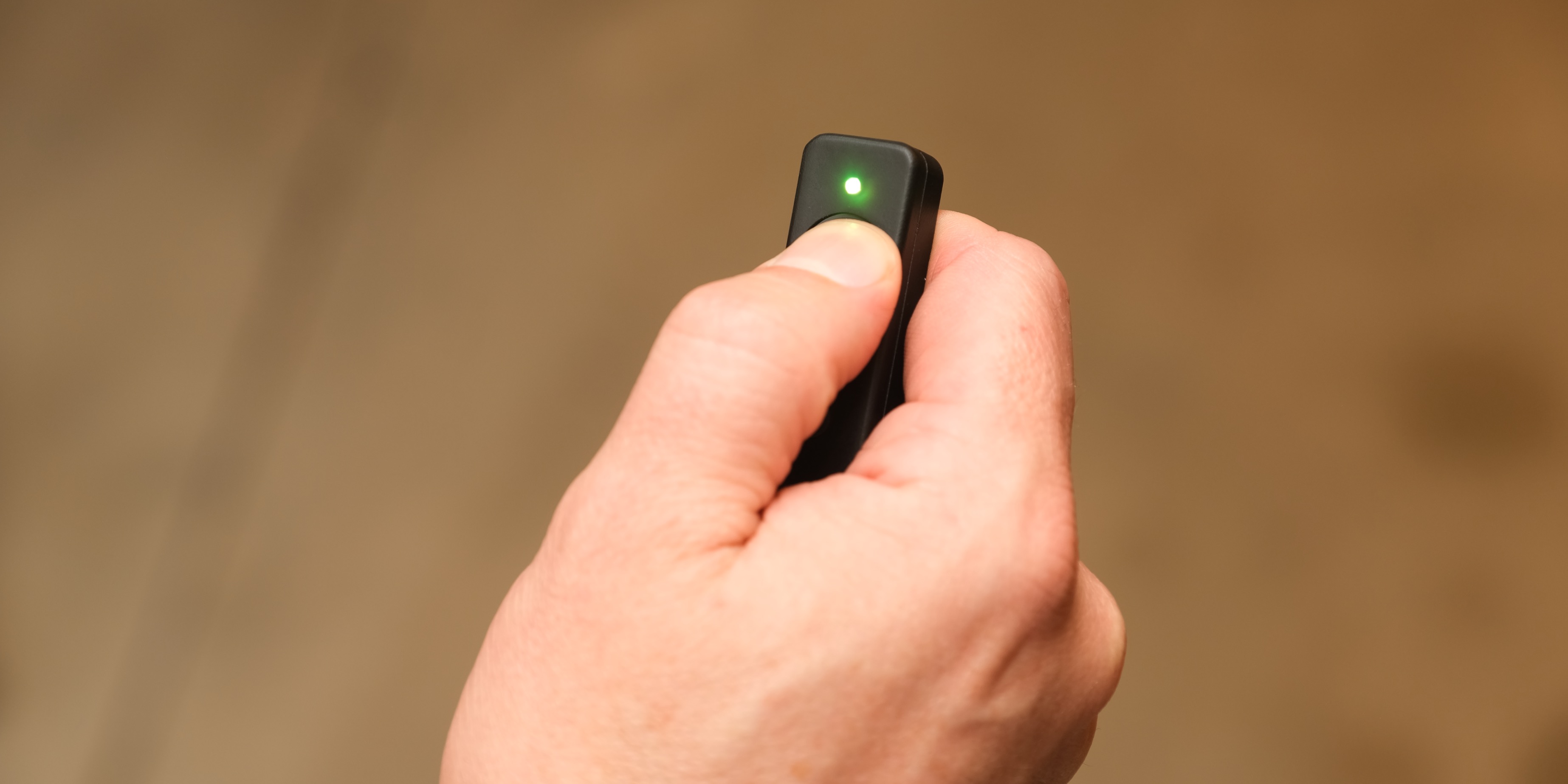 Thumb pressing the Marker Maker TX button, green LED confirming the mark