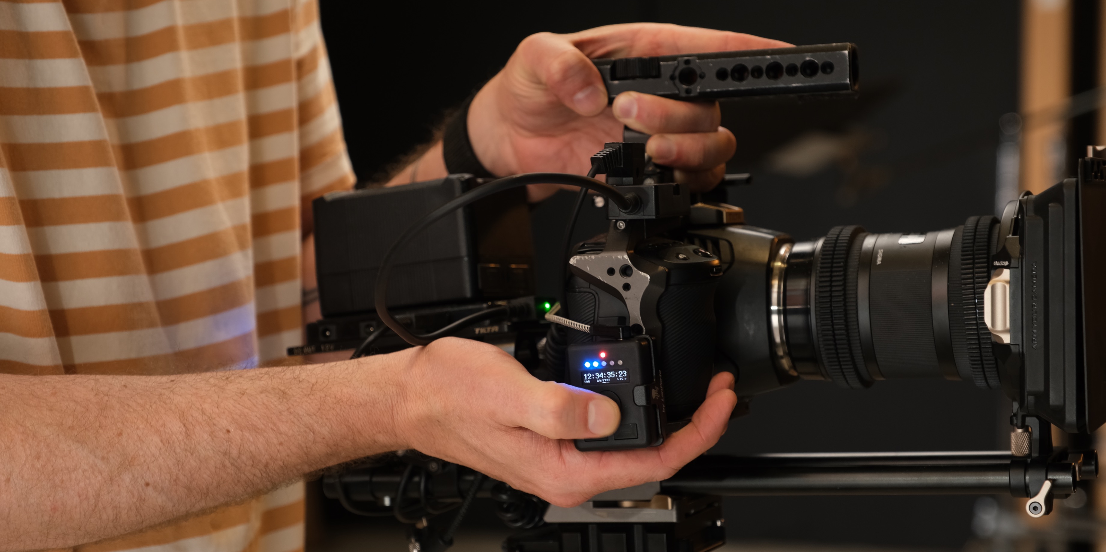 Operator working a cine camera with the Marker Maker RX clamped to the rig